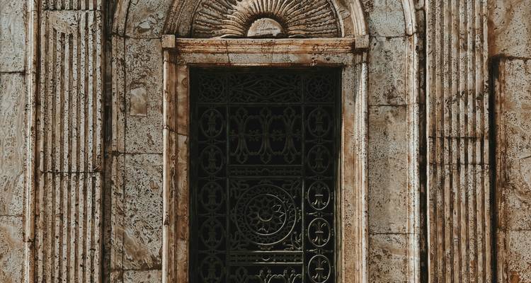 Sierlijke omheinde ingang met ingewikkelde natuursteen details.