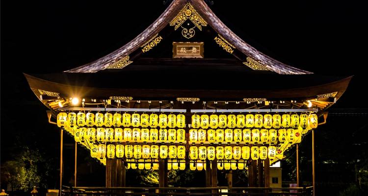 Beleuchteter traditioneller Pavillon, der nachts mit Laternen geschmückt ist.