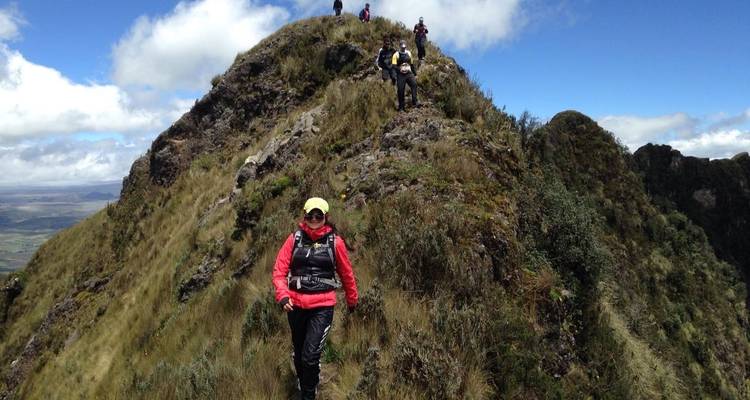 Wanderer auf einem schmalen Pfad durch bergiges Gelände.