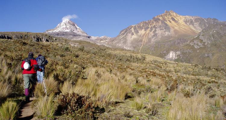 Wanderer, die in Richtung schneebedeckter Berge gehen.