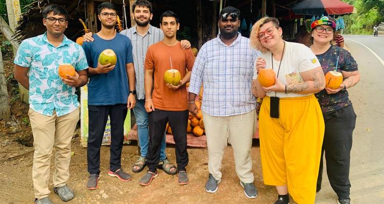 Gruppe von Menschen, die Kokosnüsse an einer Straße halten