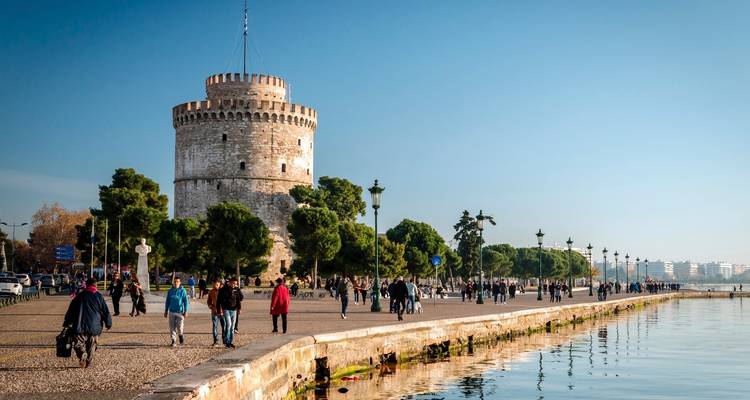 Strandpromenade in einer Stadt mit einem historischen Turm.