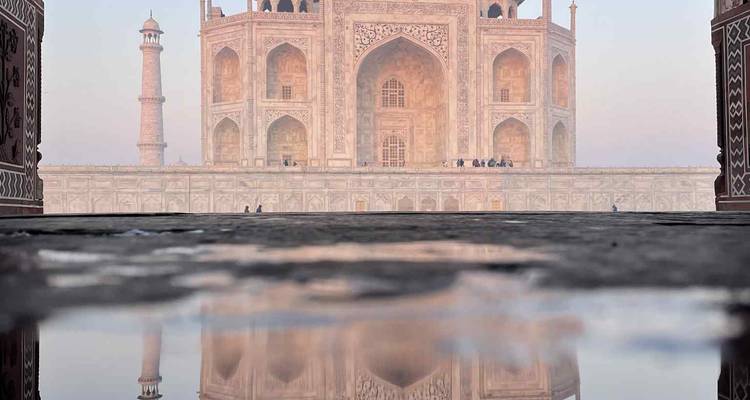 Vue rapprochée d'un mausolée emblématique avec reflet dans l'eau.