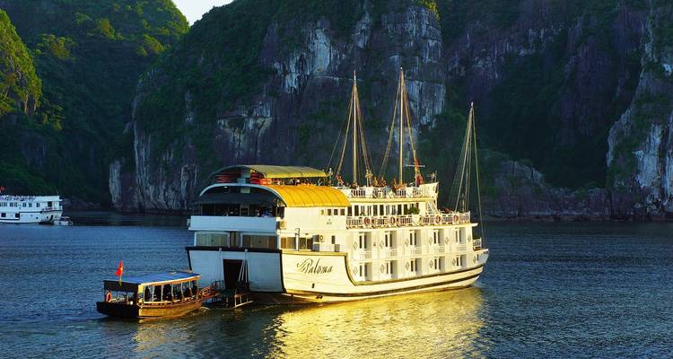 Cruiseschip en kleinere boot op Halong Bay met kalkstenen kliffen.