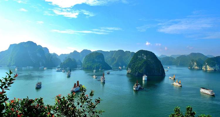 Panoramisch uitzicht op Halong Bay met boten en karstformaties.