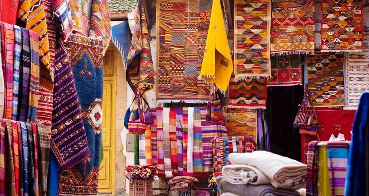 Un étalage coloré de textiles et tapis marocains.