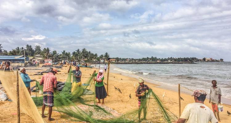 Vissers die met netten werken op een strand.