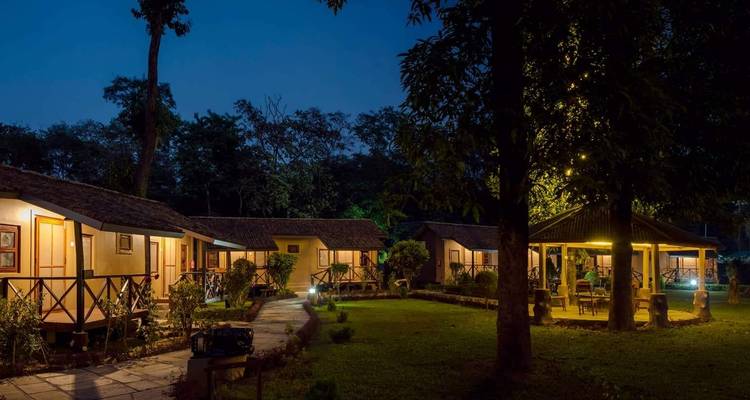 Buitenbeeld van tuinhuisjes verlicht in de nacht.