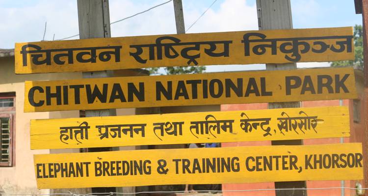 Schild für den Chitwan-Nationalpark in Nepal, in mehreren Sprachen.