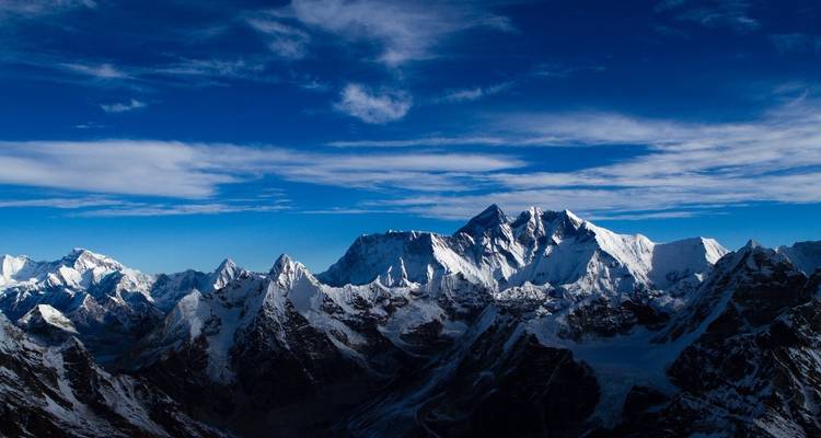 Vue époustouflante de l'Himalaya avec un ciel bleu foncé et des sommets enneigés.