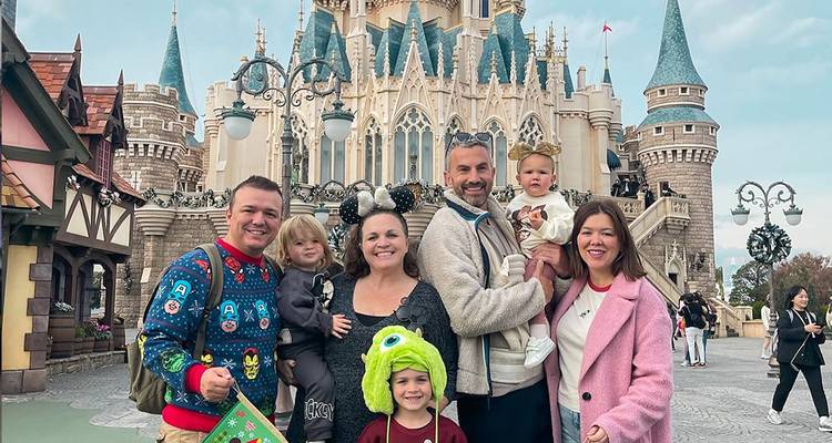 Gruppe von Menschen, die vor einem Schloss posieren.
