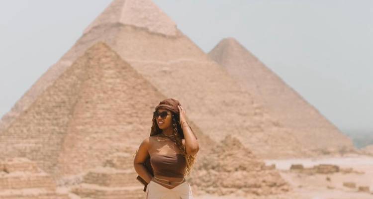 Femme qui pose devant les pyramides par une journée ensoleillée.
