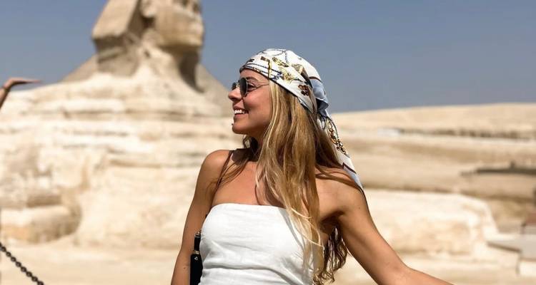 Femme souriante avec le Sphinx en arrière-plan.