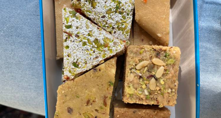 Assortiment van Indiase zoetigheden met pistachenoten in een blikken doos