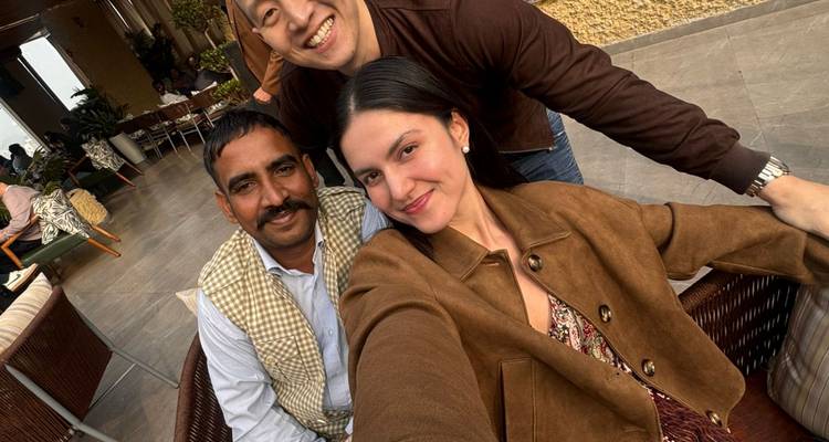Repetir imagen: tres amigos posando para una selfie alegre en una terraza al aire libre con decoración moderna.
