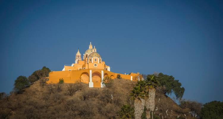 Iglesia de la cima de la colina de color naranja de Cholula de pie contra un cielo azul despejado