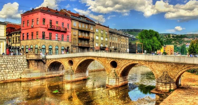 Pont historique coloré au-dessus d'une rivière dans une ville.