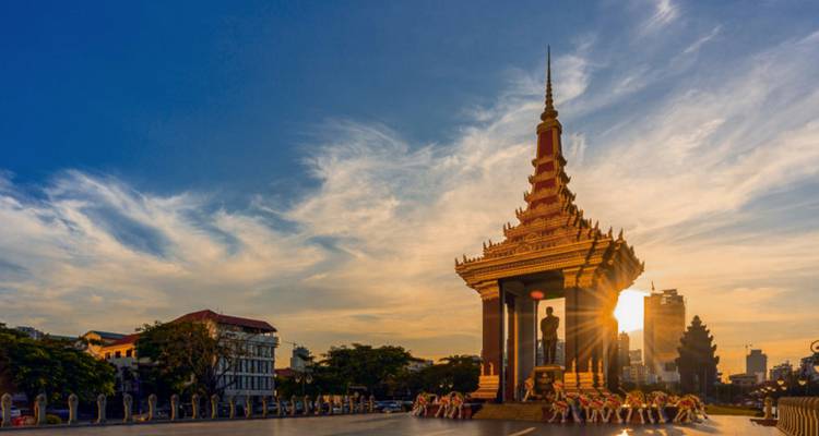 Onafhankelijksheidsmonument van Phnom Penh afgetekend tegen een levendige zonsonderganghemel.