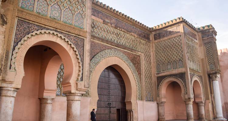 Stadttor von Meknes mit kunstvollen Verzierungen und Fußgänger.