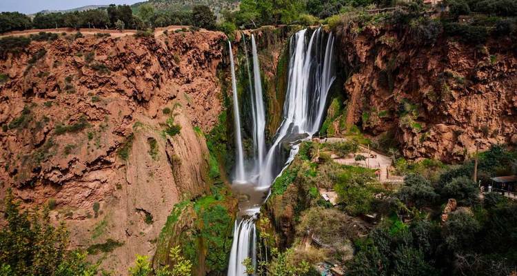 Wide view of Ouzoud Falls amidst lush foliage.