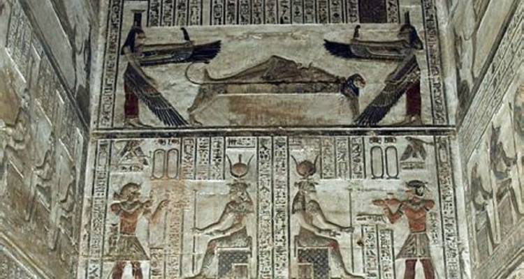 Anciens reliefs peints et hiéroglyphes représentant des divinités égyptiennes à l'intérieur d'une chambre de temple.