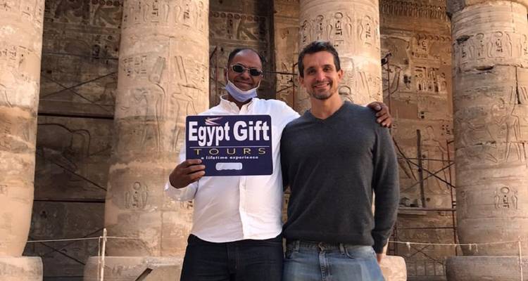 Zwei Männer halten ein Schild mit Tempelsäulen.