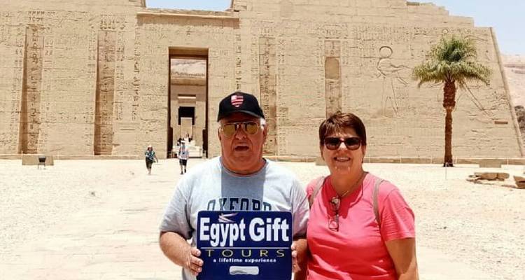 Paar hält ein Schild vor einem alten Gebäude.