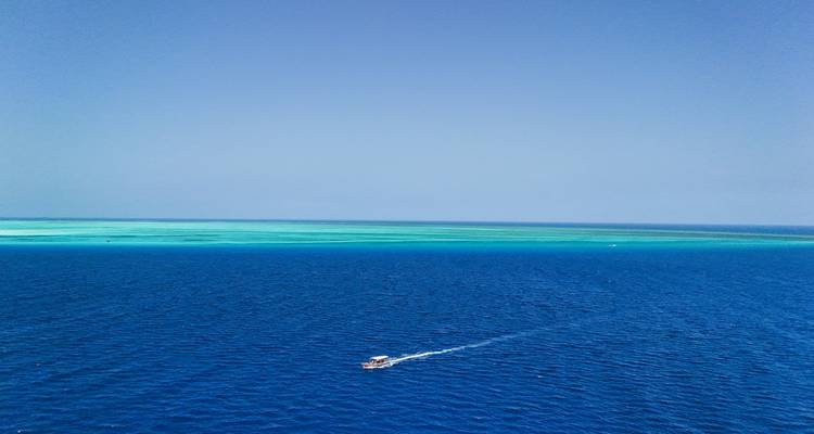 Un bateau filant à travers les eaux sombres et bleues de l'océan.