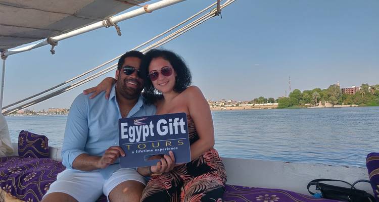 Stel op een boot met een tourbordje en de Nijl op de achtergrond.