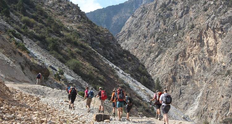 Randonnée de groupe à travers un sentier de montagne rocheux.