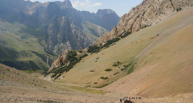 Grand groupe faisant de la randonnée le long d'un sentier de montagne escarpé.