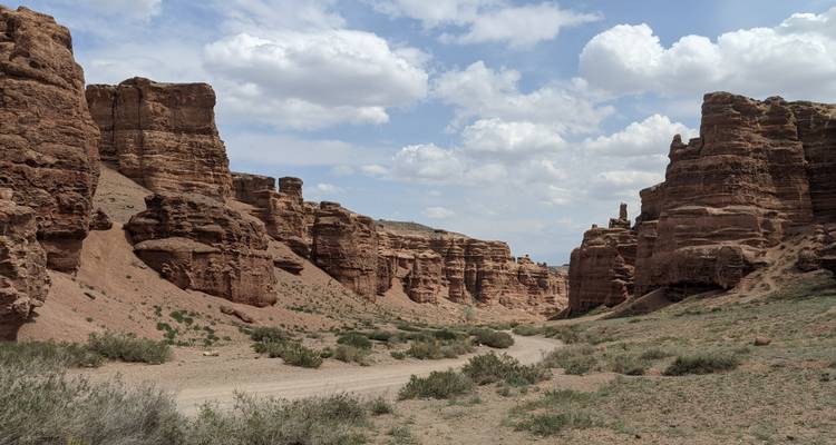 Canyon with rugged rock formations under a cloudy sky.