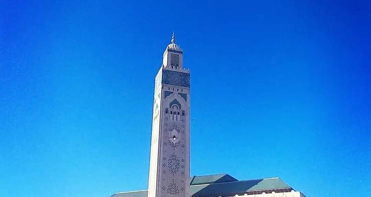 El minarete elevado de la Mezquita Hassan II se alza contra un cielo azul impecable.