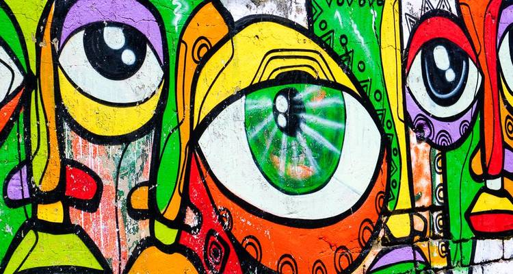 Farbenfrohe abstrakte Graffiti an einer Wand mit großen Augen.