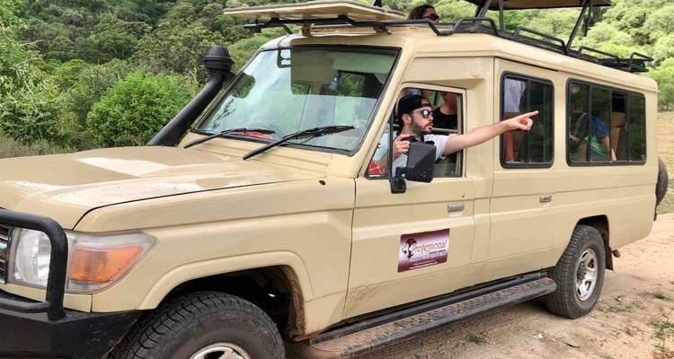 Safari vehicle with a person pointing out wildlife.