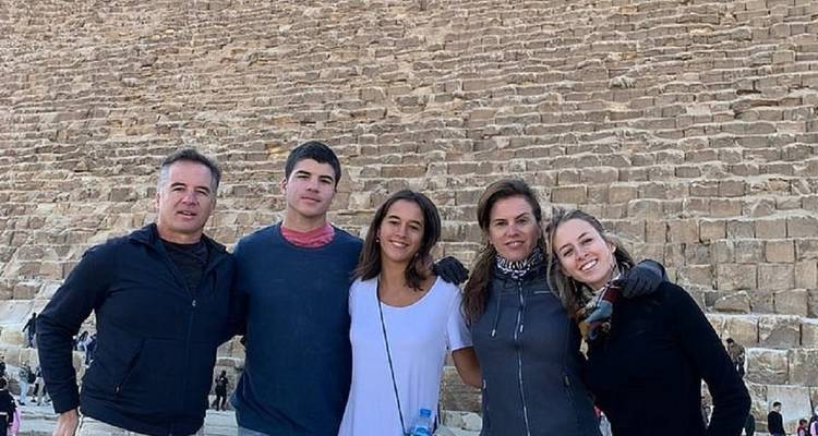 Un groupe posant devant un décor de pierres de pyramide.