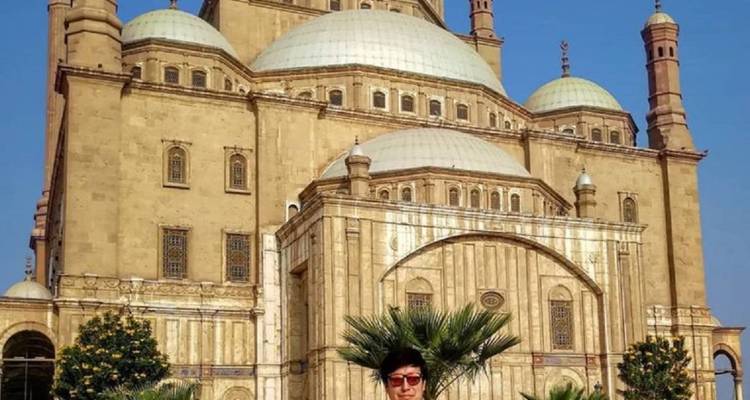 Une personne qui pose avec la mosquée historique en arrière-plan.