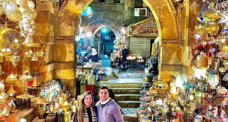 Des gens profitant d'un marché coloré éclairé par des lanternes.