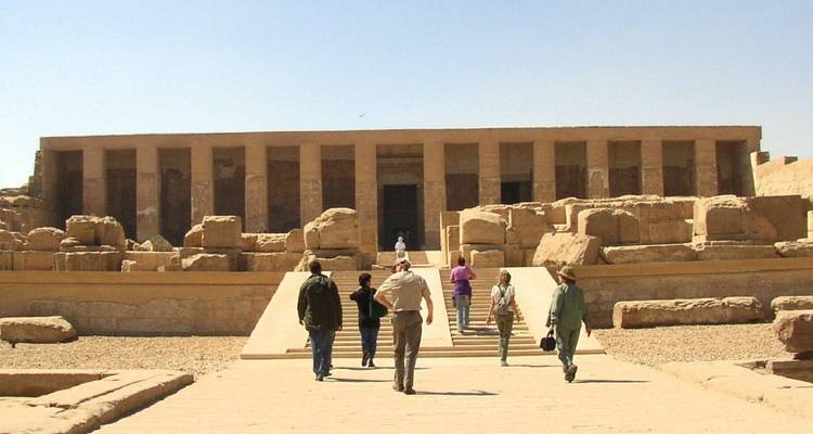 Les voyageurs marchent vers la façade monumentale du Temple de Seti Ier à Abydos.