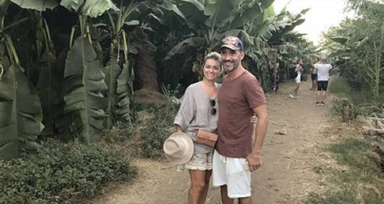 Paar posiert in ländlicher Umgebung mit Bananenbäumen.