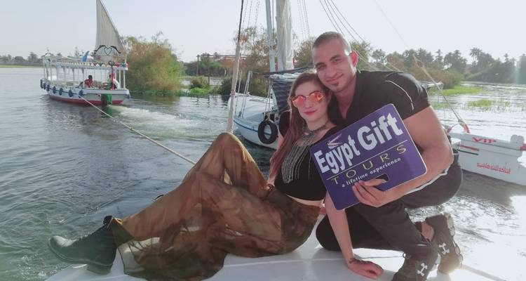 Touristen, die auf einem Boot mit einem Schild posieren.