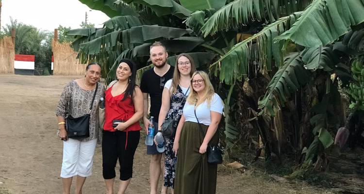 Groupe de personnes posant dans un cadre tropical avec de grandes feuilles de bananier.