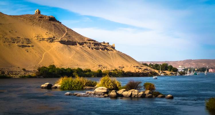 Blick auf Assuan mit einer friedlichen Flussszene unter klarem Himmel.