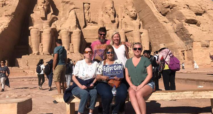 Kleine groep zit met rondleidingsbord voor de gevel van Abu Simbel tempel