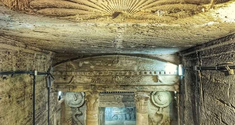 Tunnel ancien avec hiéroglyphes et sculptures.