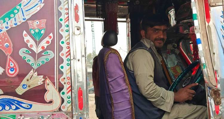 Fahrer sitzt in einem dekorierten Fahrzeug und zeigt kulturelle Designs.