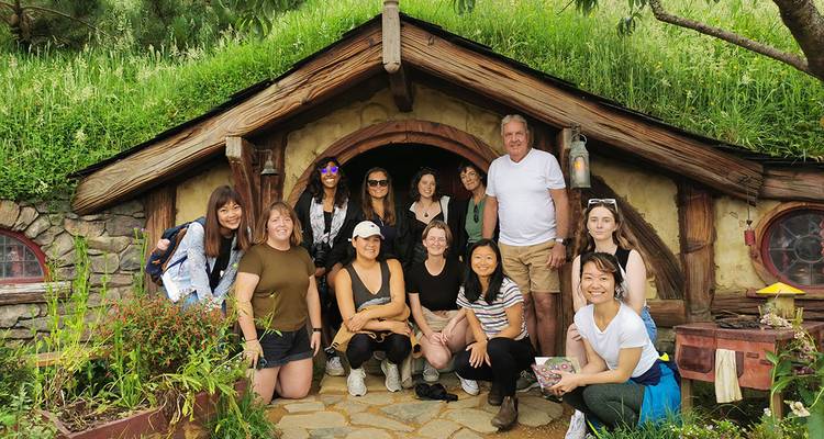 Group at Hobbiton movie set entrance.