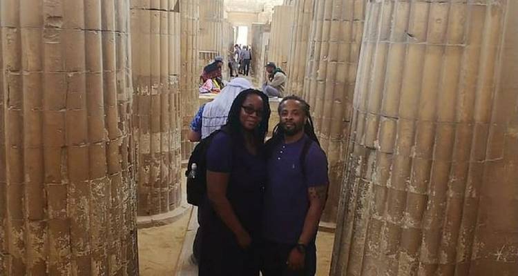 Couple debout au milieu de colonnes de pierre.