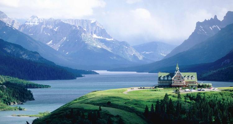 Ein großartiges Hotel mit Blick auf einen ruhigen See, umgeben von Bergen.
