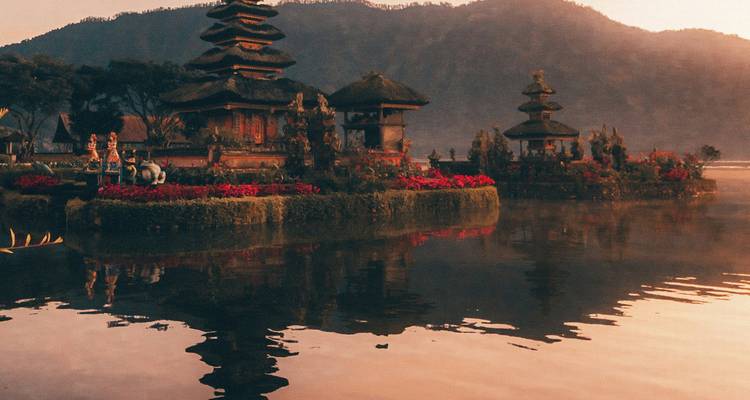 Traditional Balinese temple on a lake during sunset.